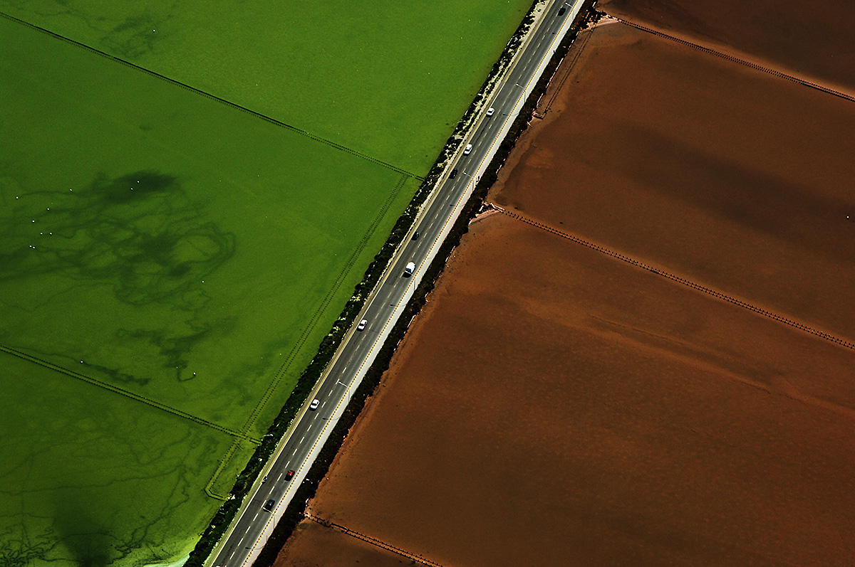 Abstract Aerial View of Red and Green Water Fields with a Road in the middle, Sardinia, Italy.