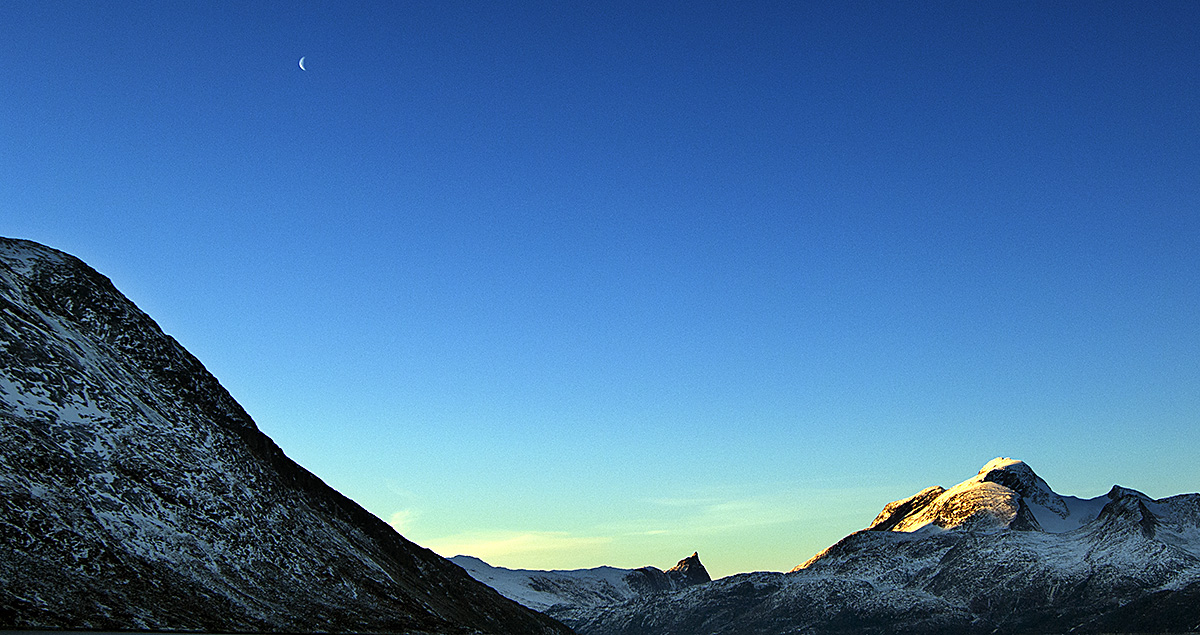 View of Landscape with Mountains and Tiny Moon in Davis Strait, Greenland.
